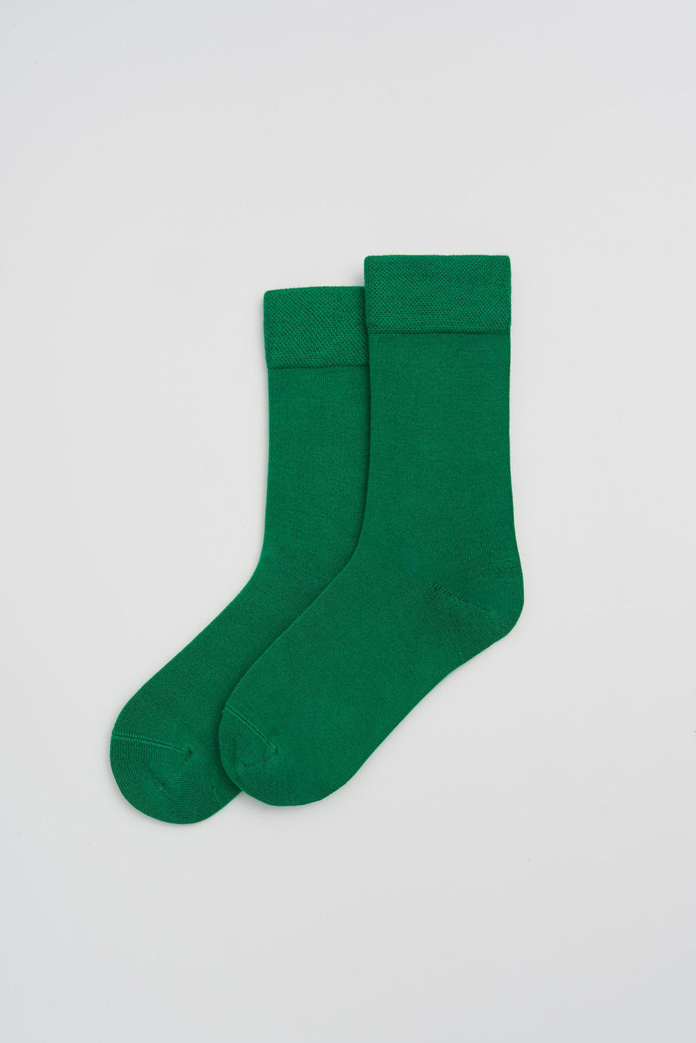Pair of green bamboo socks on a light grey background