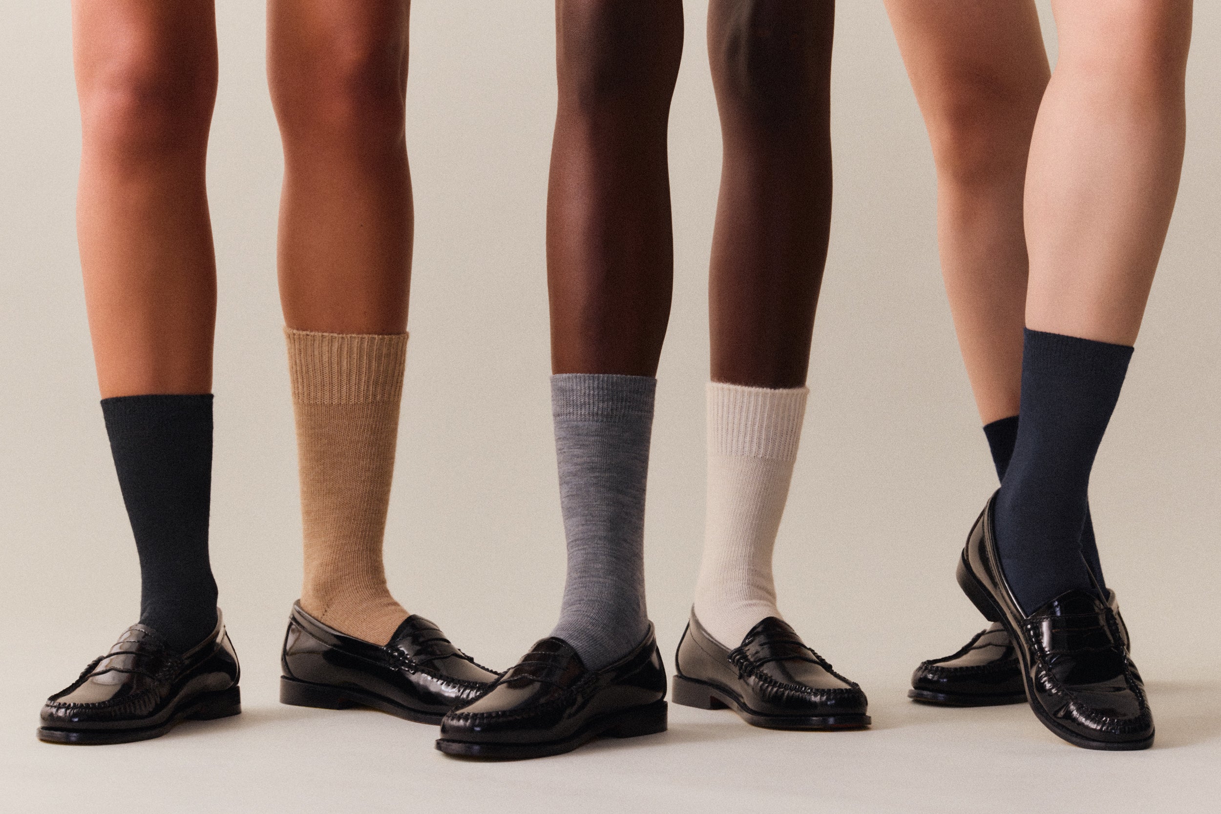 3 pairs of legs wearing merino socks and black loafers