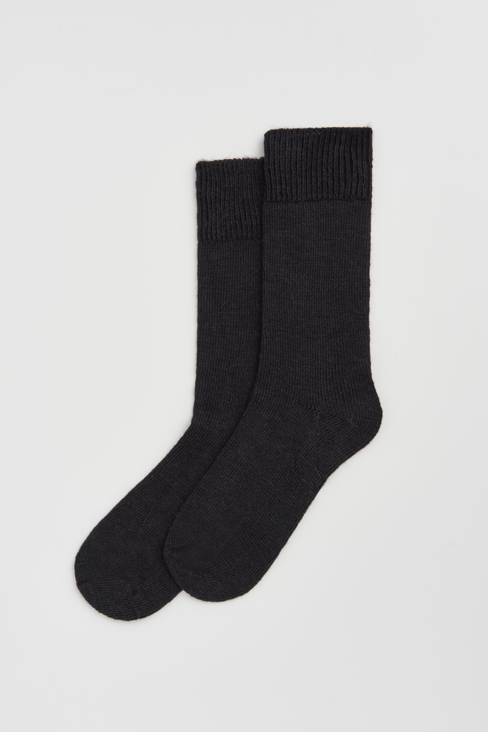 Pair of black calf-length alpaca socks  on a light grey background