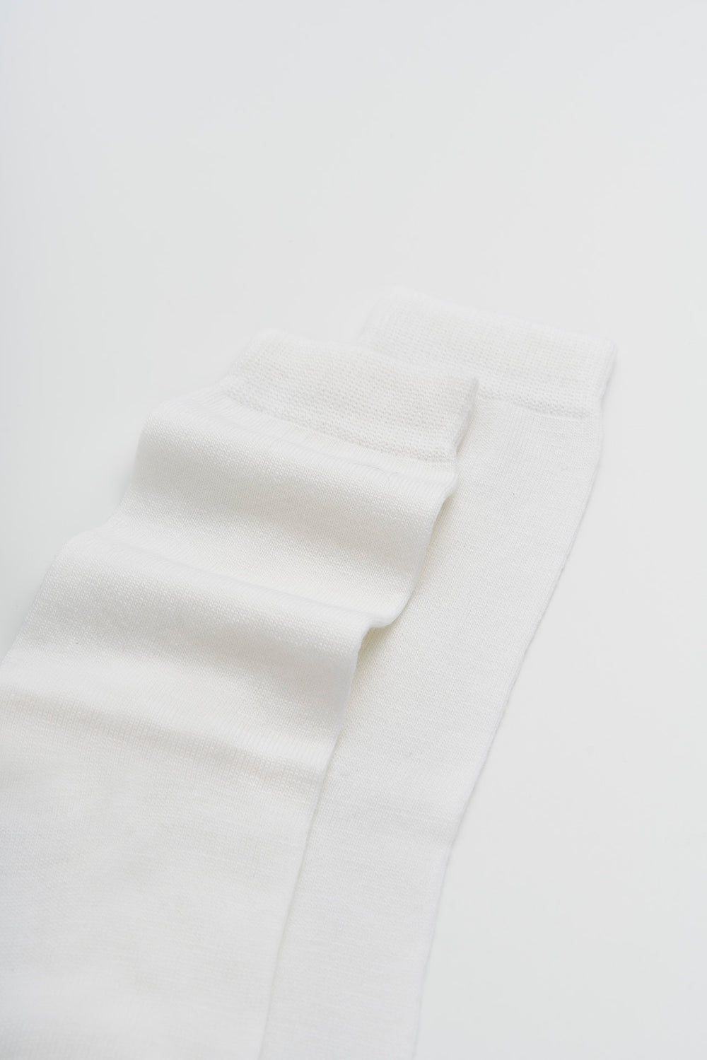 White merino socks on a light grey background
