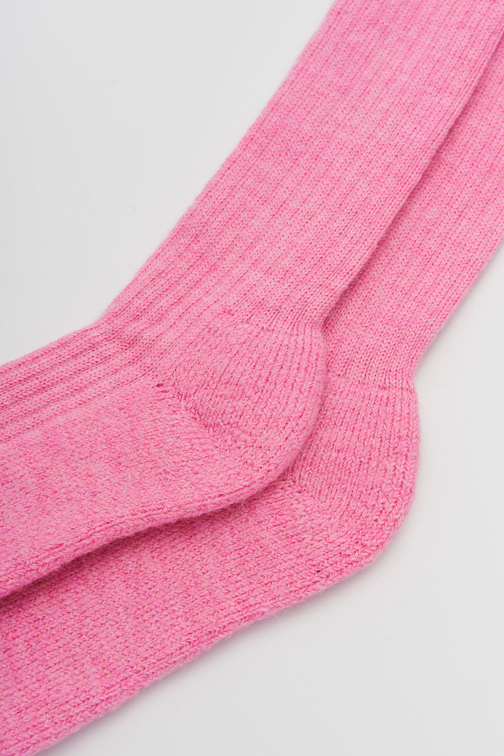 Close-up of sherbet pink wool knee high socks on a light grey background