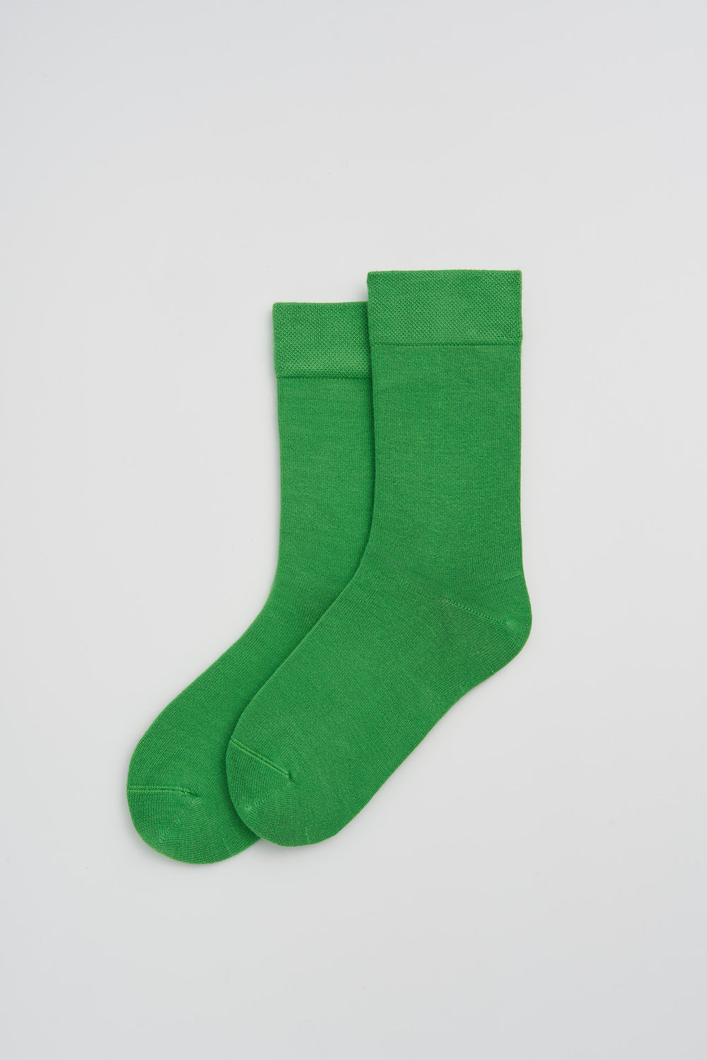 Pair of green bamboo socks on a light grey background