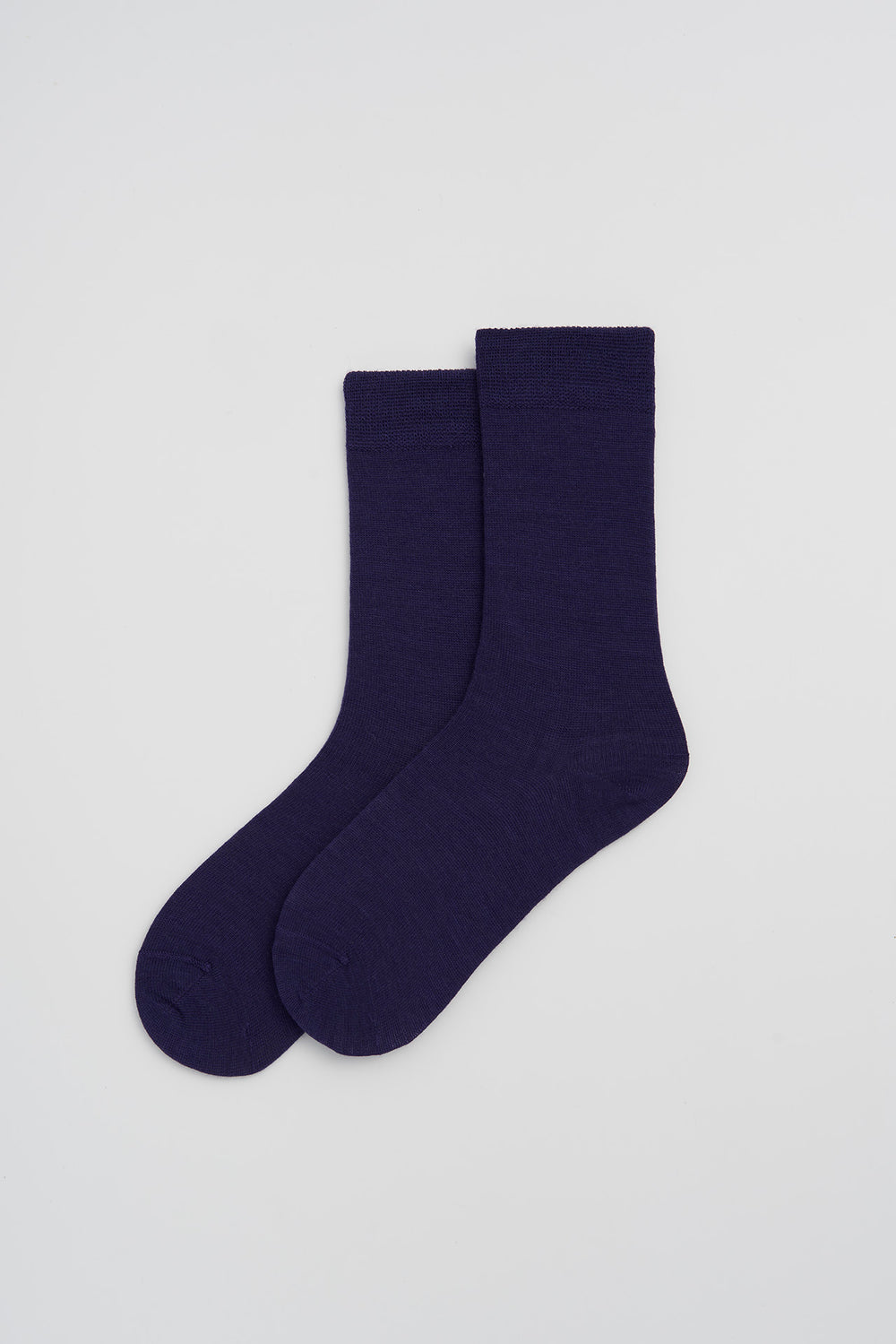 Pair of purple merino socks on a light grey background