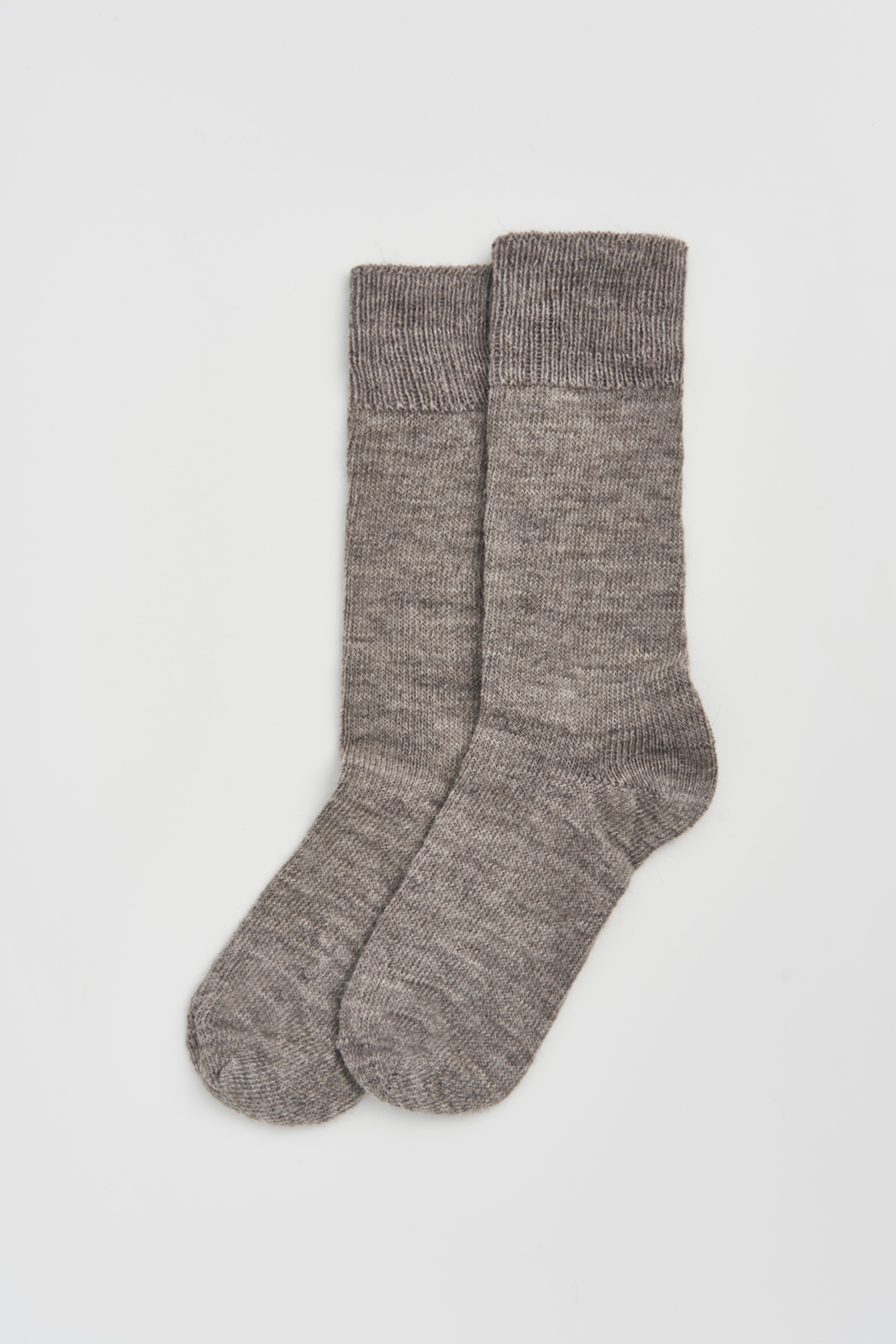 Pair of grey calf-length alpaca socks on a light grey background