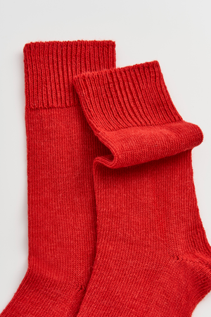 Close-up of a pair of red calf-length alpaca socks on a white background