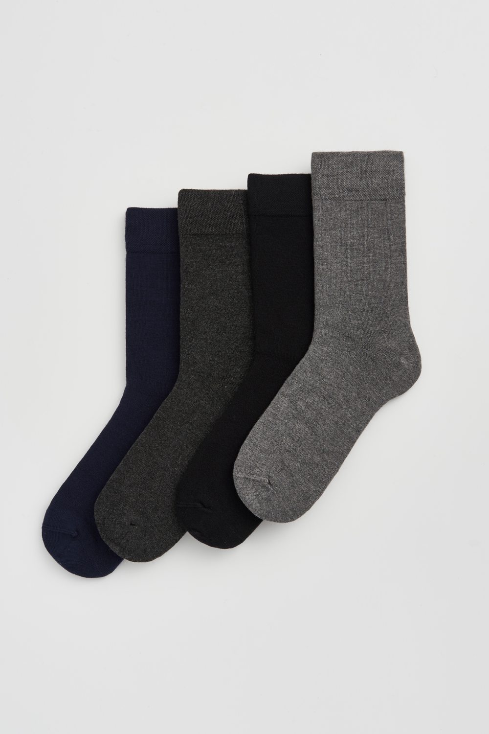 Set of four calf-length bamboo socks in navy, dark grey, black and grey on a light grey background