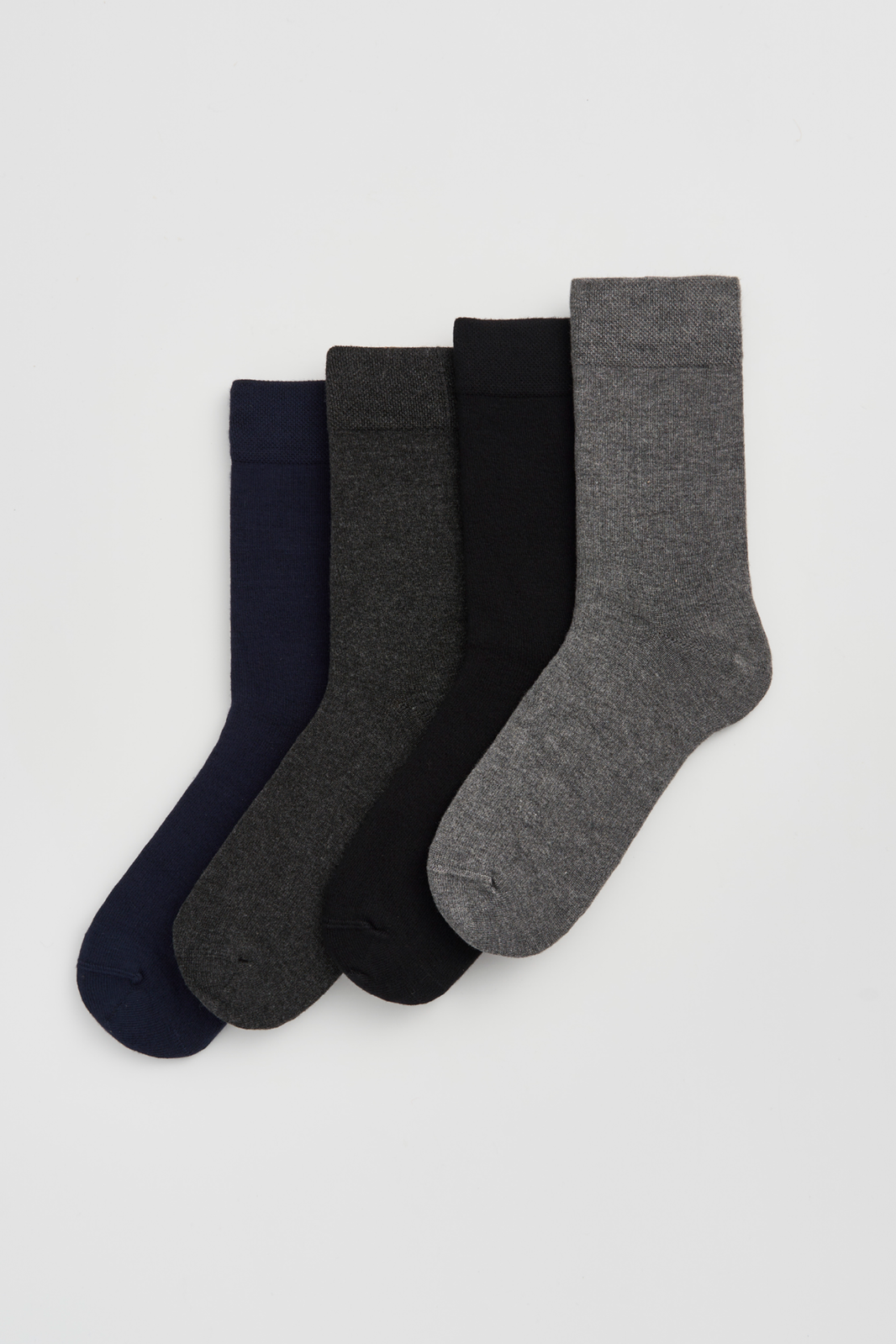 Set of four calf-length bamboo socks in navy, dark grey, black and grey on a light grey background