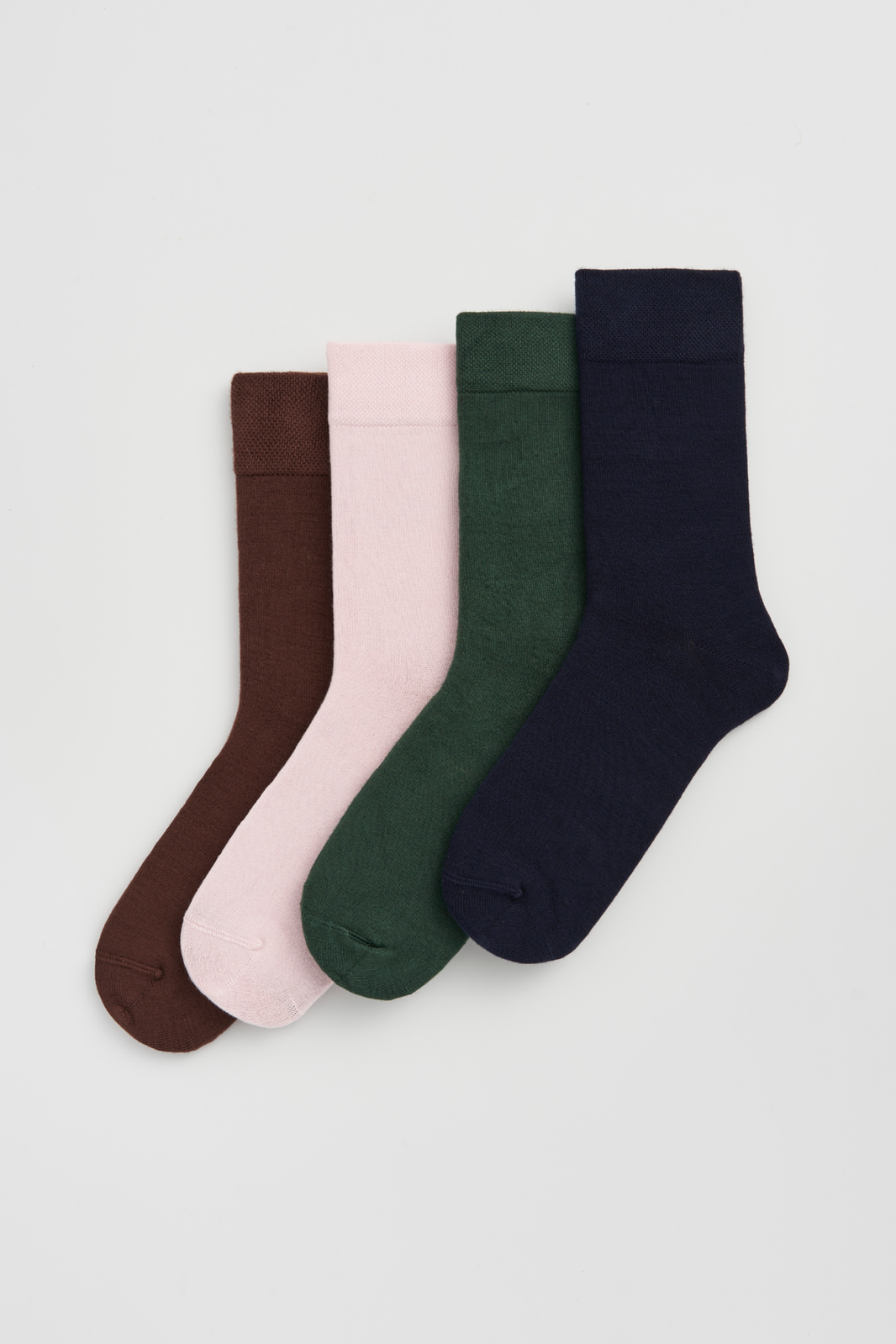 Four pairs of calf-length bamboo socks in brown, pink, green, and navy blue on a light grey background