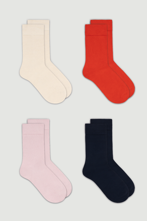 Four pairs of calf length bamboo socks in cream, red, pink, and dark blue on a white background.
