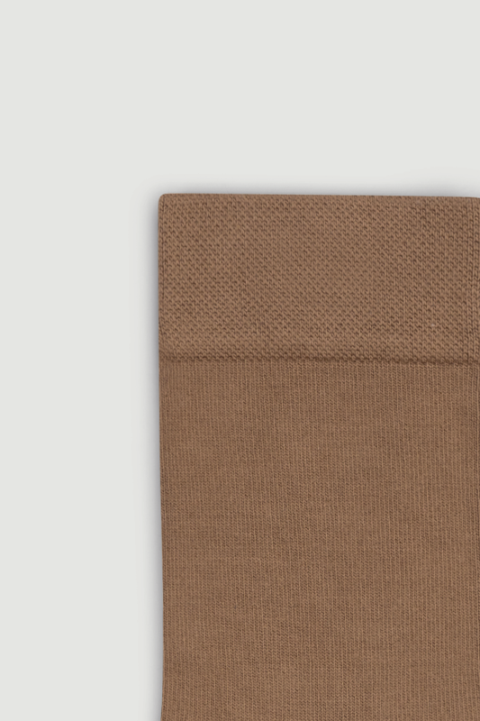 Close-up of the top of a light brown bamboo calf length sock on a white background