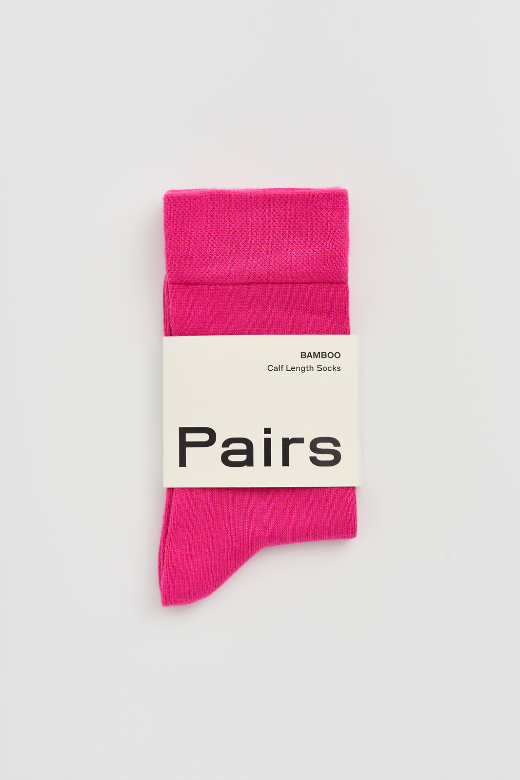Pink calf-length bamboo sock with a 'Pairs' packaging band on a light grey background