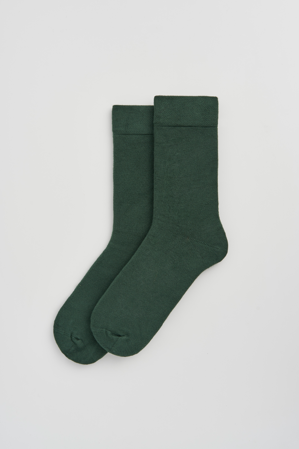 Pair of dark green calf-length bamboo socks on a light grey background