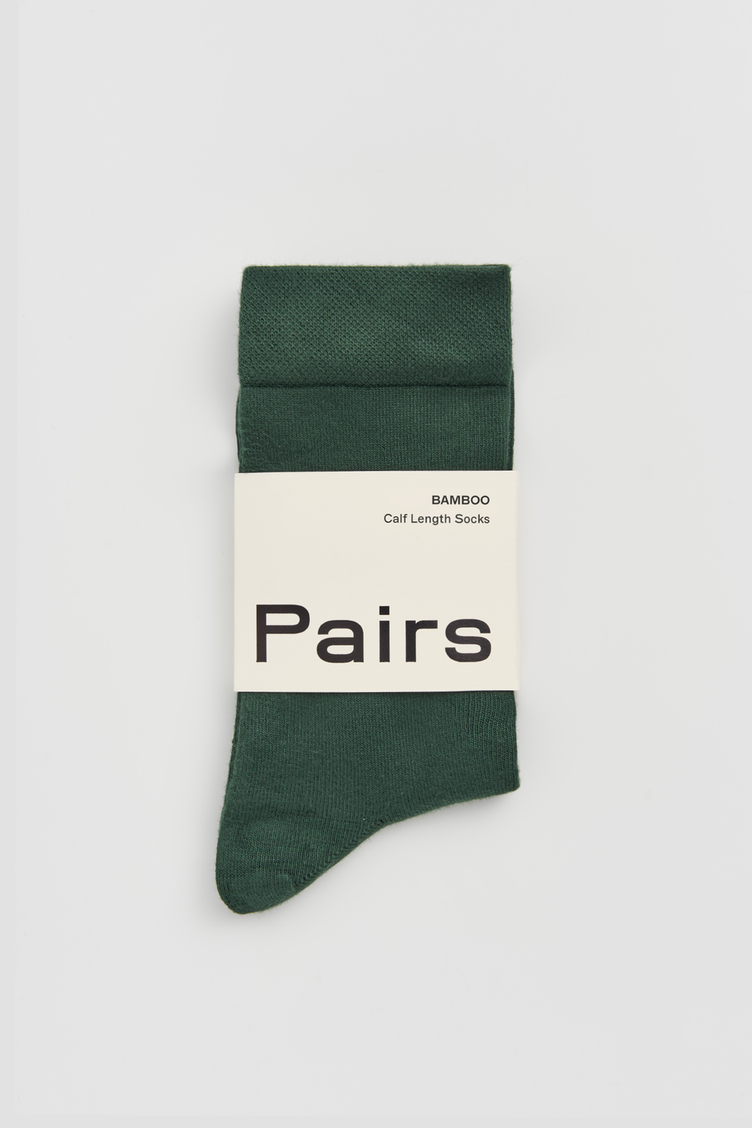 Green calf-length bamboo sock with a 'Pairs' packaging band on a light grey background