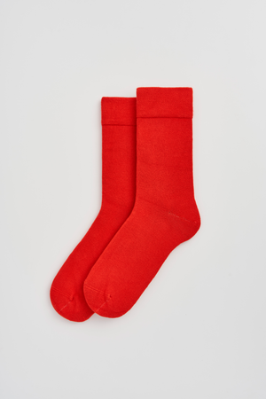 Pair of red calf-length bamboo socks on a light grey background