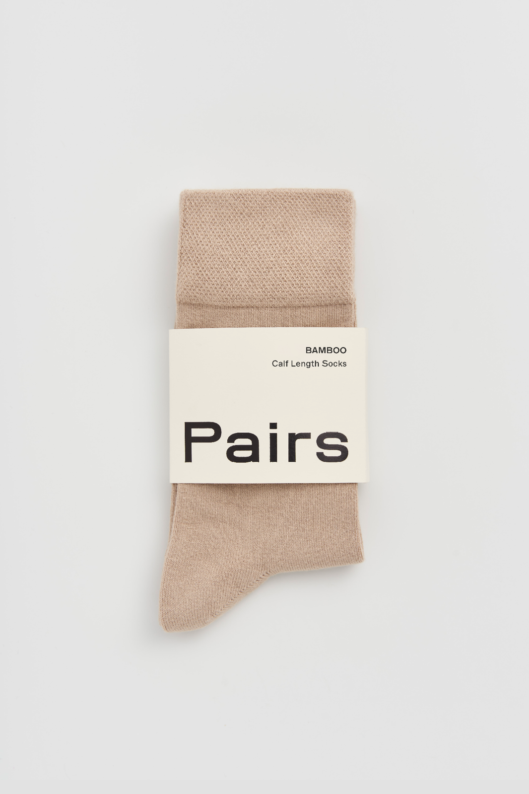 Light beige calf-length bamboo sock with a 'Pairs' packaging band on a light grey background