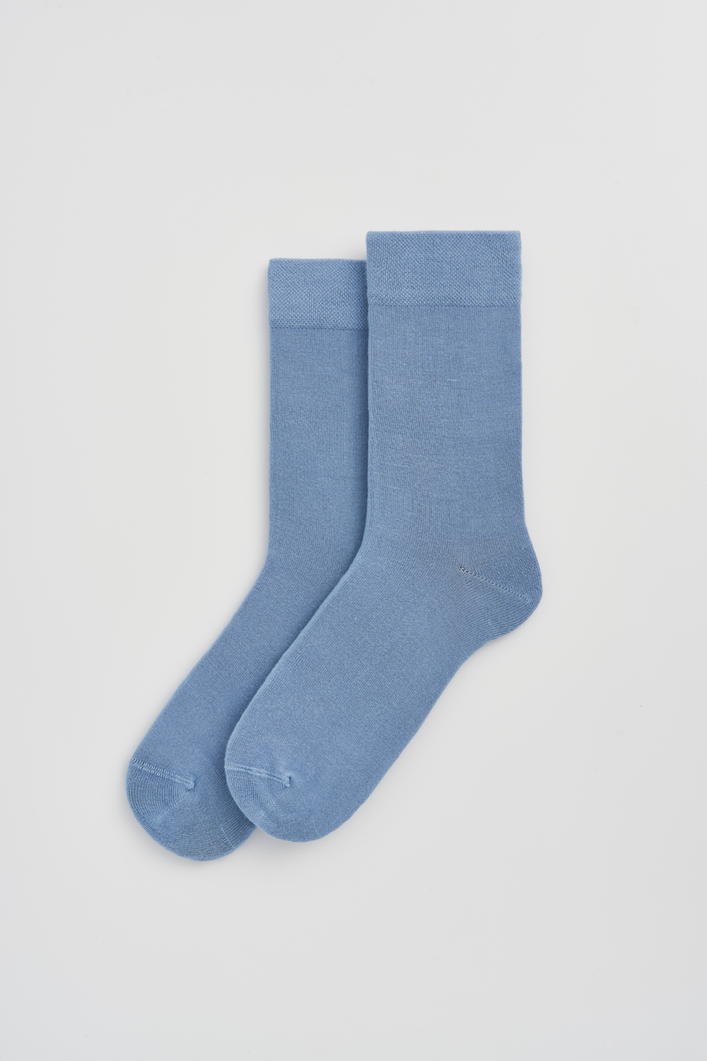 Pair of light blue calf-length bamboo socks on a white background