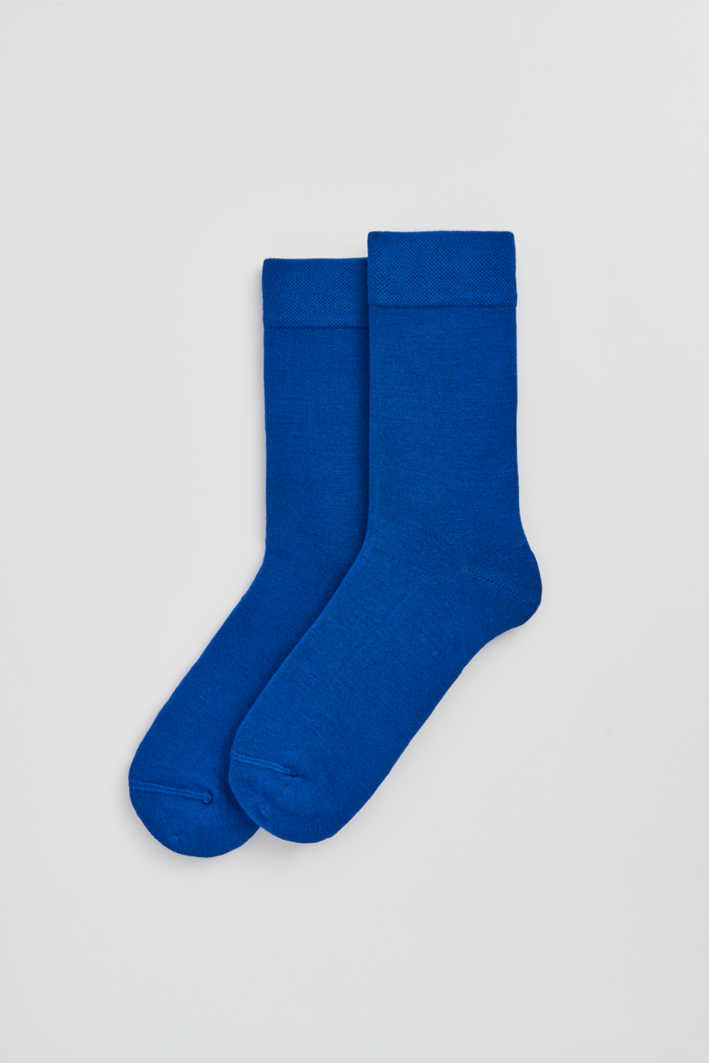 Pair of bright blue calf-length bamboo socks on a light grey background