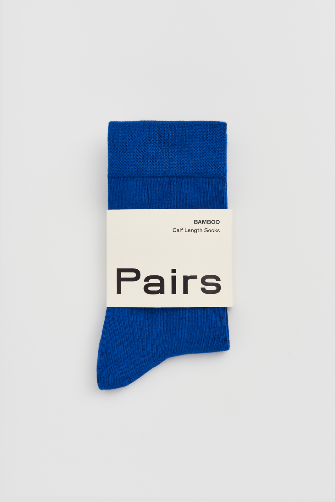 Bright blue calf-length bamboo sock with a 'Pairs' packaging band on a light grey background