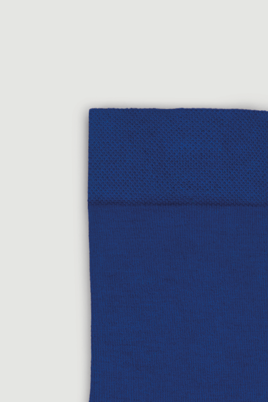 Close-up of the top of a blue bamboo calf length sock on a white background