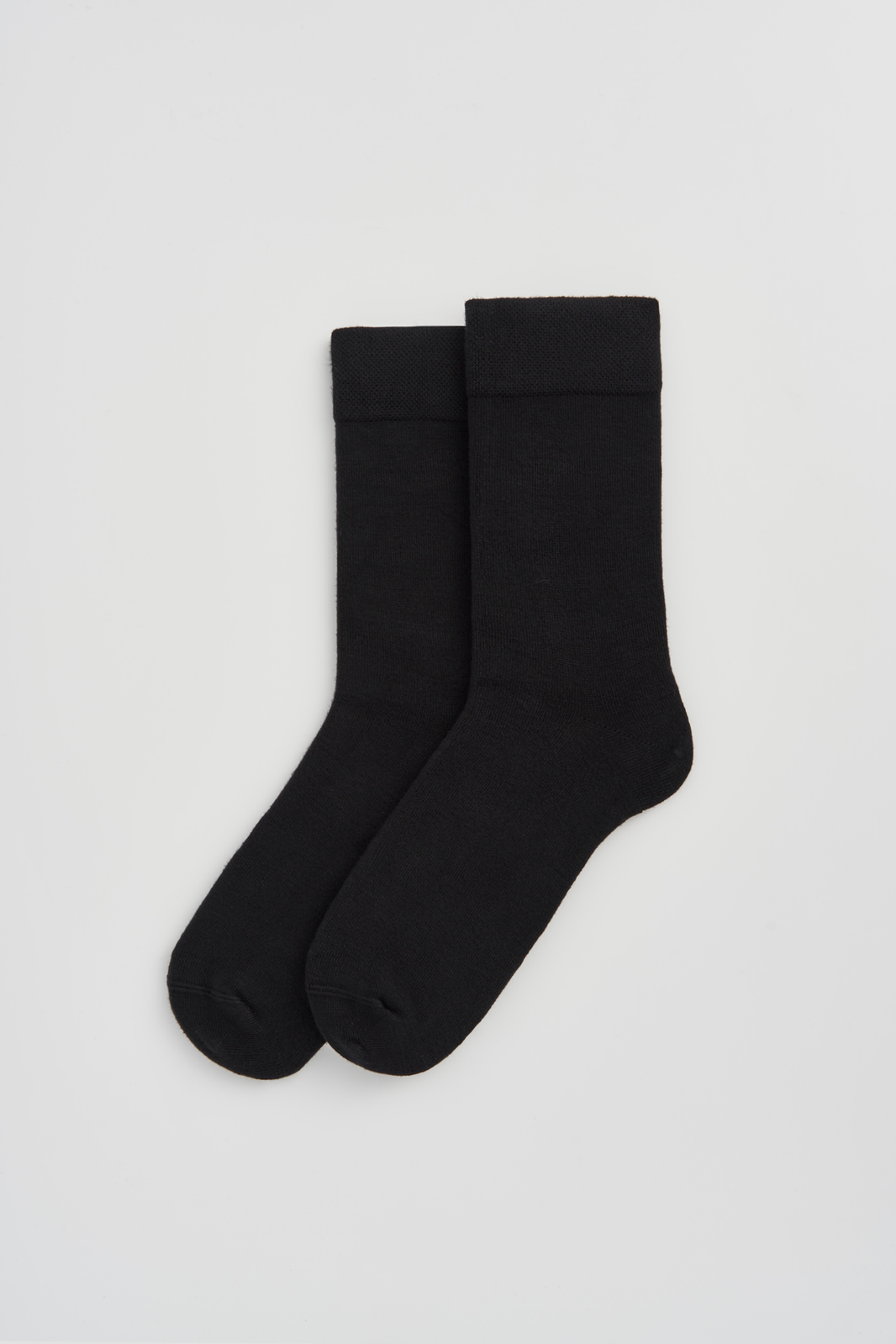 Pair of black calf-length bamboo socks  on a light grey background