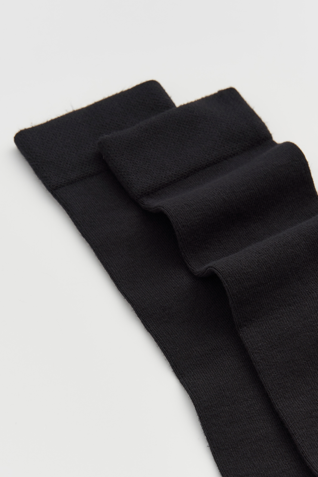 Black calf-length bamboo socks on a light grey background