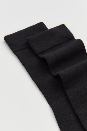 Black calf-length bamboo socks on a light grey background
