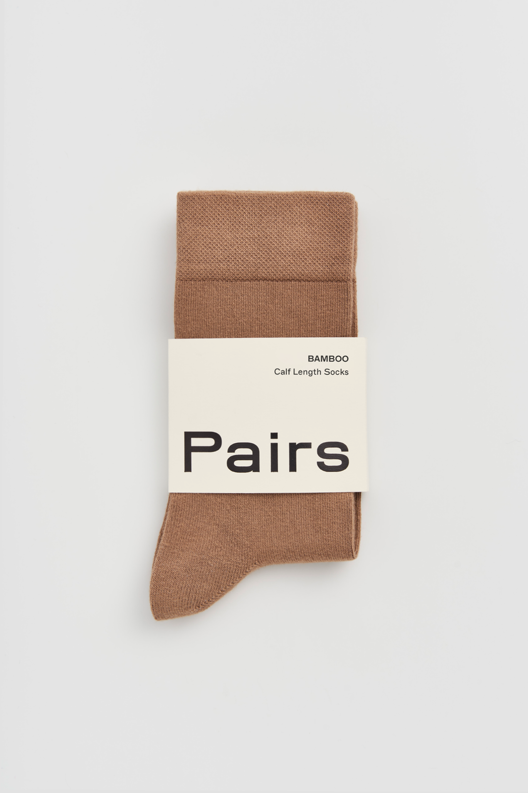 Beige calf-length bamboo sock with a 'Pairs' packaging band on a light grey background
