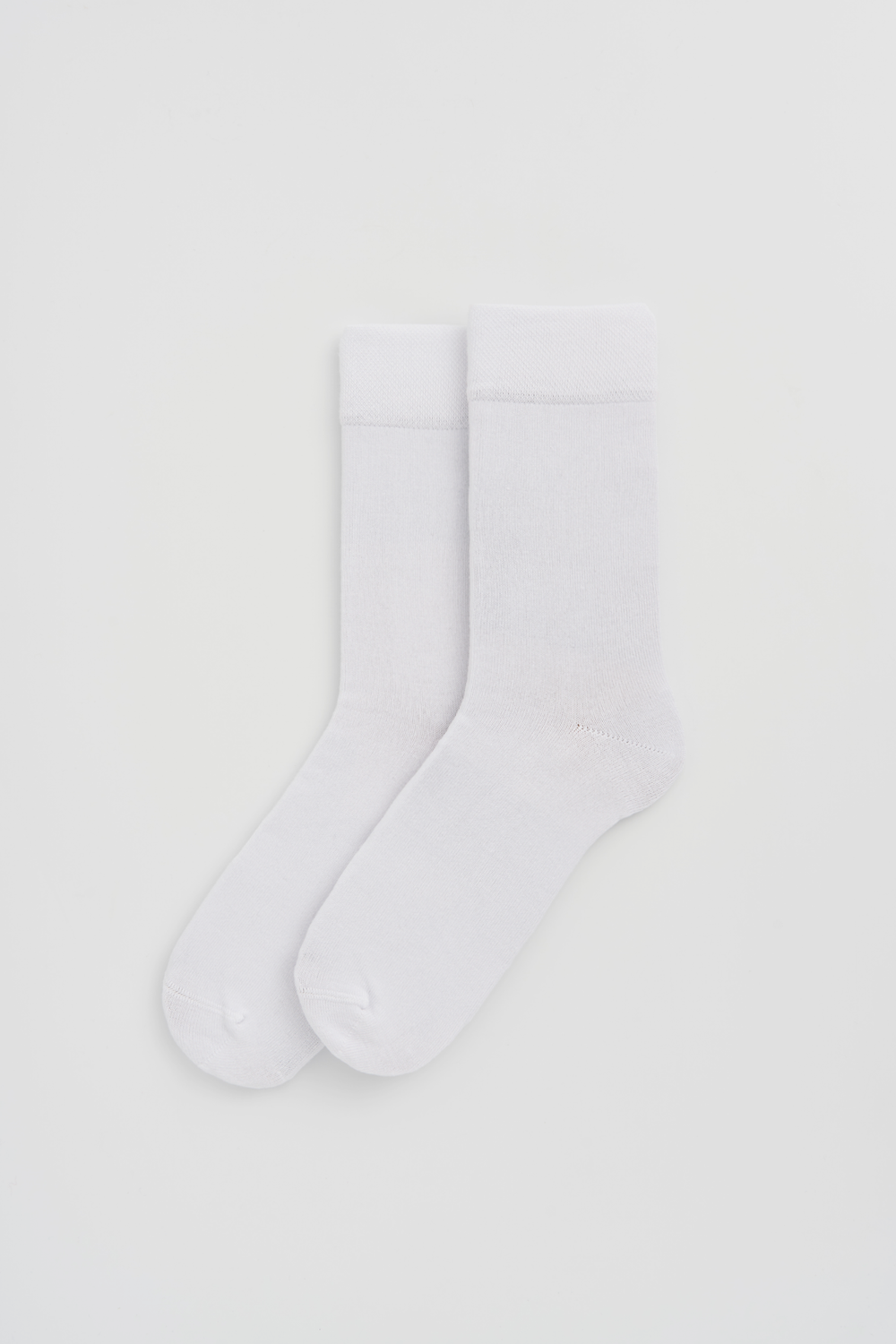White calf-length bamboo socks on a light grey background