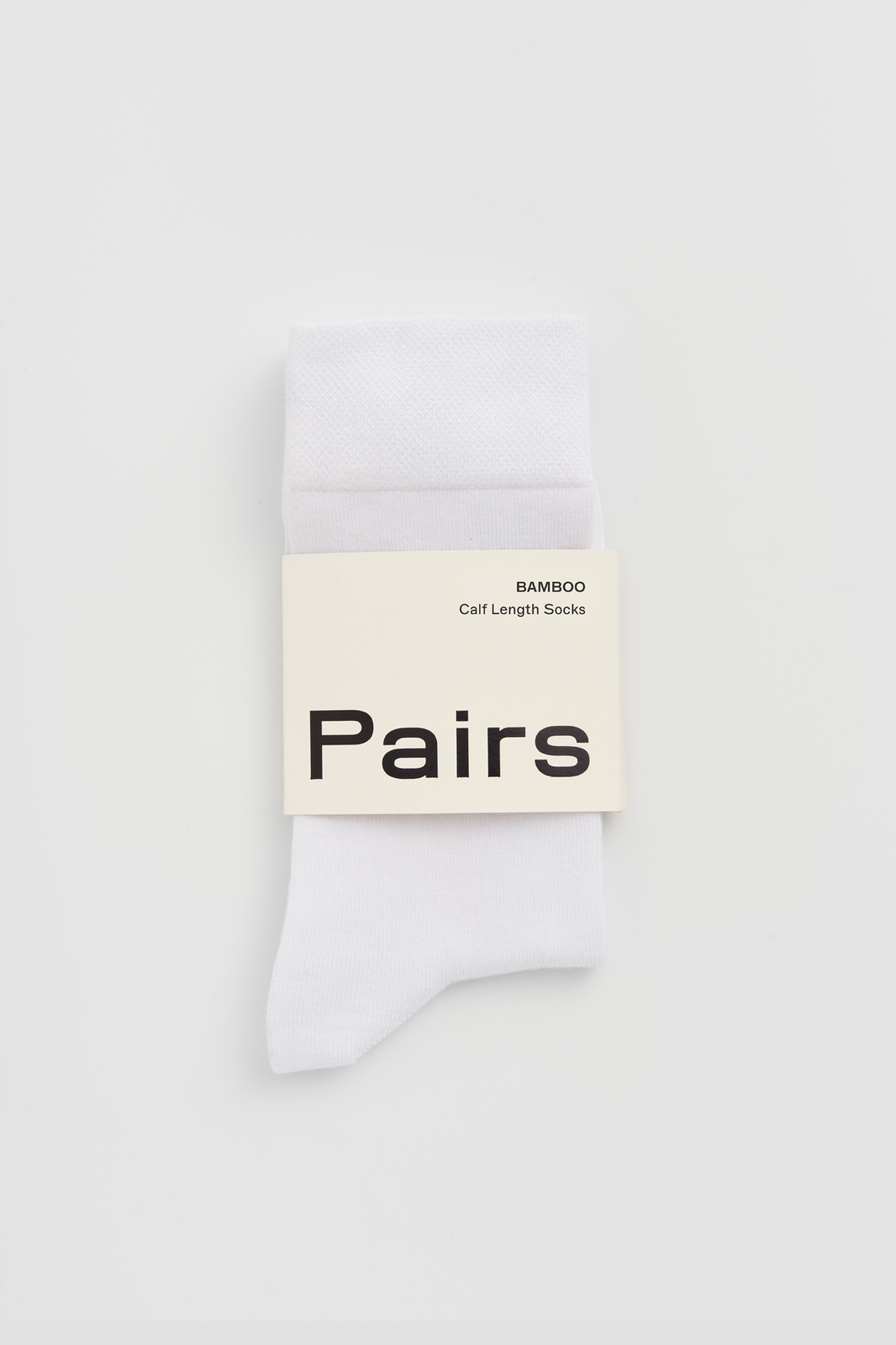 White calf-length bamboo sock with 'Pairs' packaging band on a white background