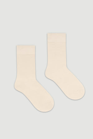 Pair of cream bamboo calf length socks on a white background