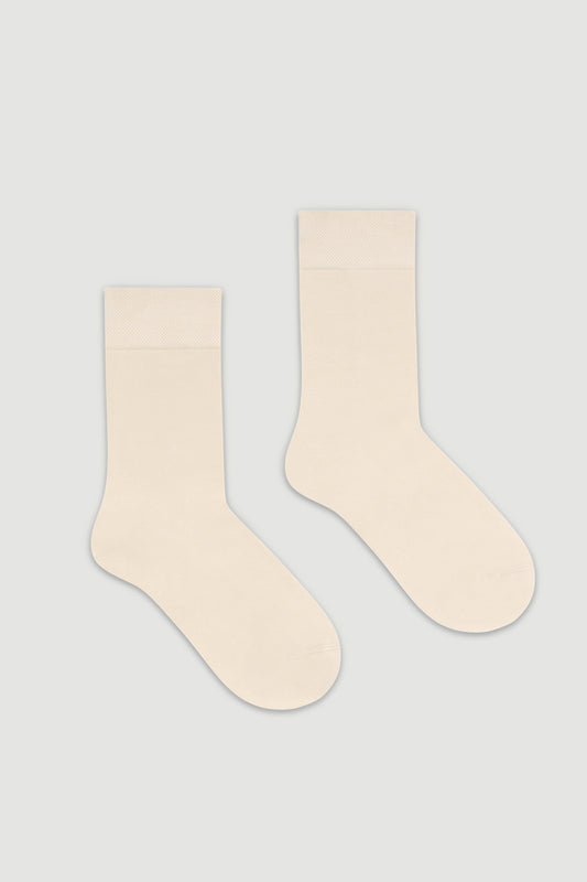 Pair of cream bamboo calf length socks on a white background