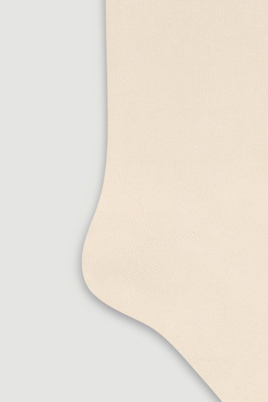 Close-up of the heel of a cream bamboo calf length sock on a white background