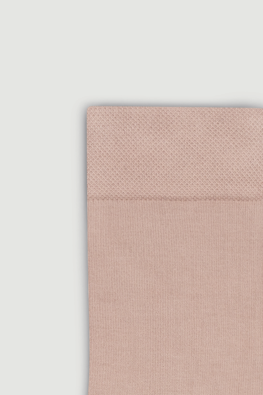 Close-up of the top of a light pink bamboo calf length sock on a white background