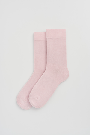 Pair of light pink calf-length bamboo socks on a light grey background