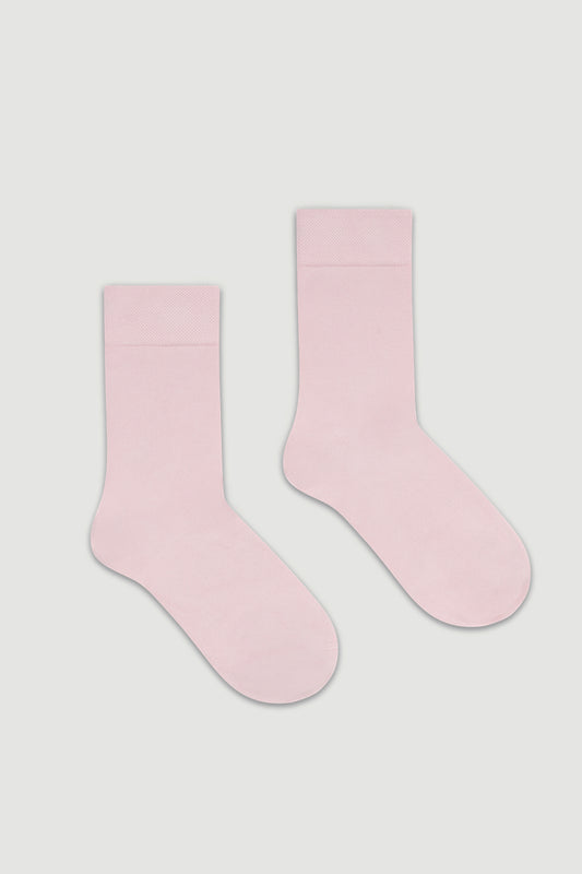 Pair of light pink calf length bamboo socks on a white background