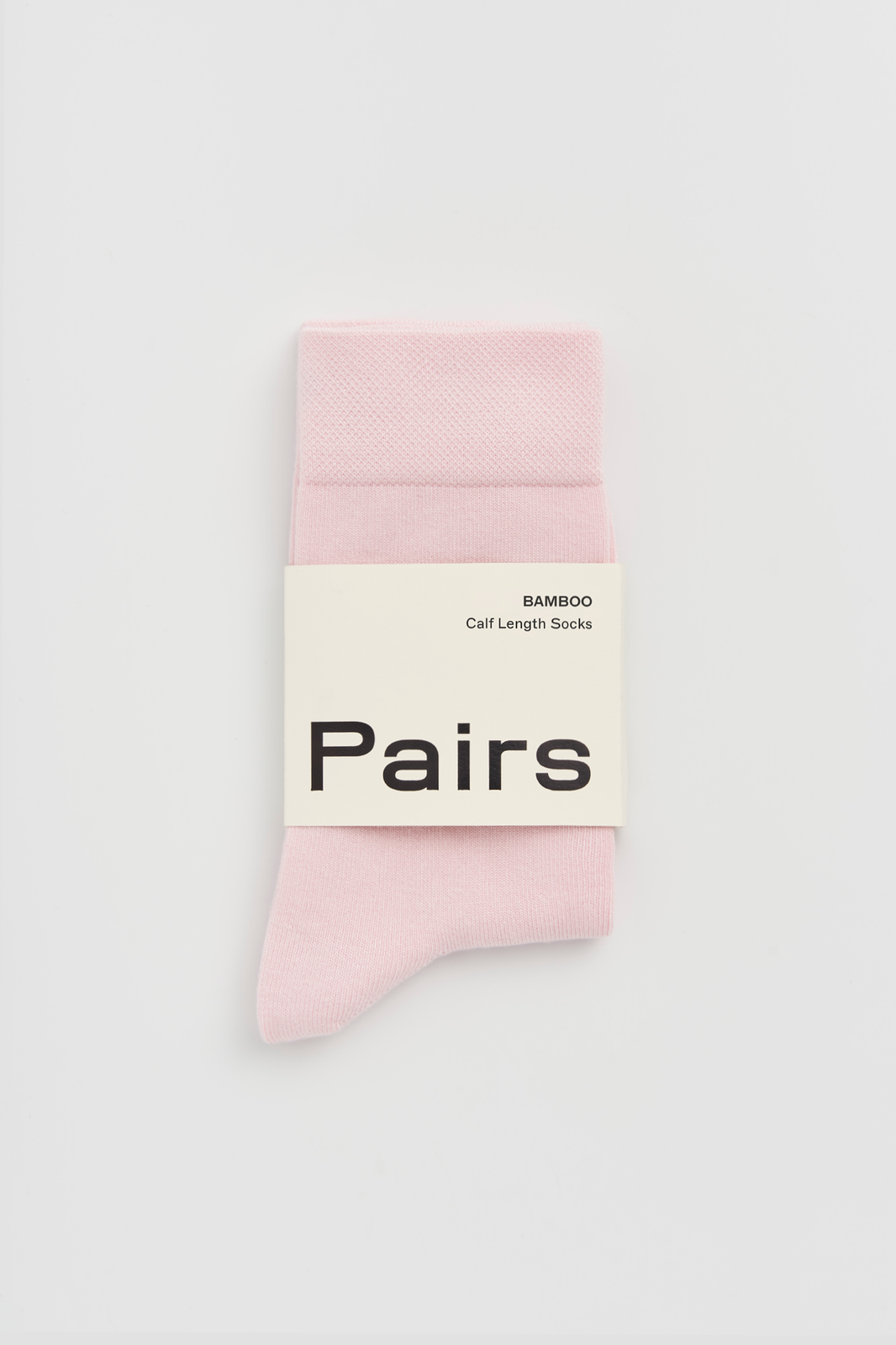 Pink calf-length bamboo sock with a 'Pairs' packaging band on a light grey background