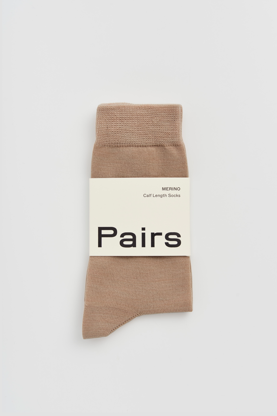 Beige calf-length merino sock with a 'Pairs' packaging band on a light grey background