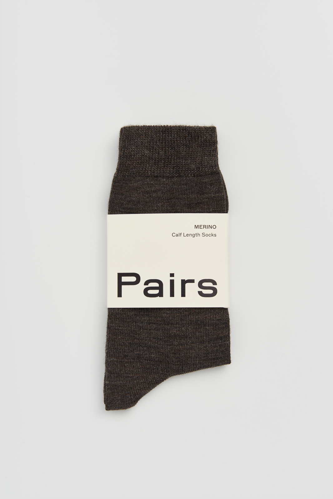 Dark brown calf-length merino sock with a 'Pairs' packaging band on a light grey background