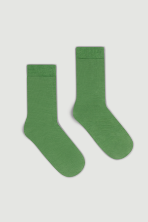 Pair of green calf length merino socks on a white background