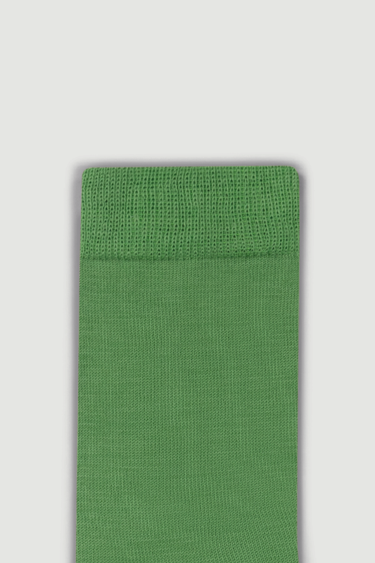 Close-up of the top of a green calf length merino sock on a white background