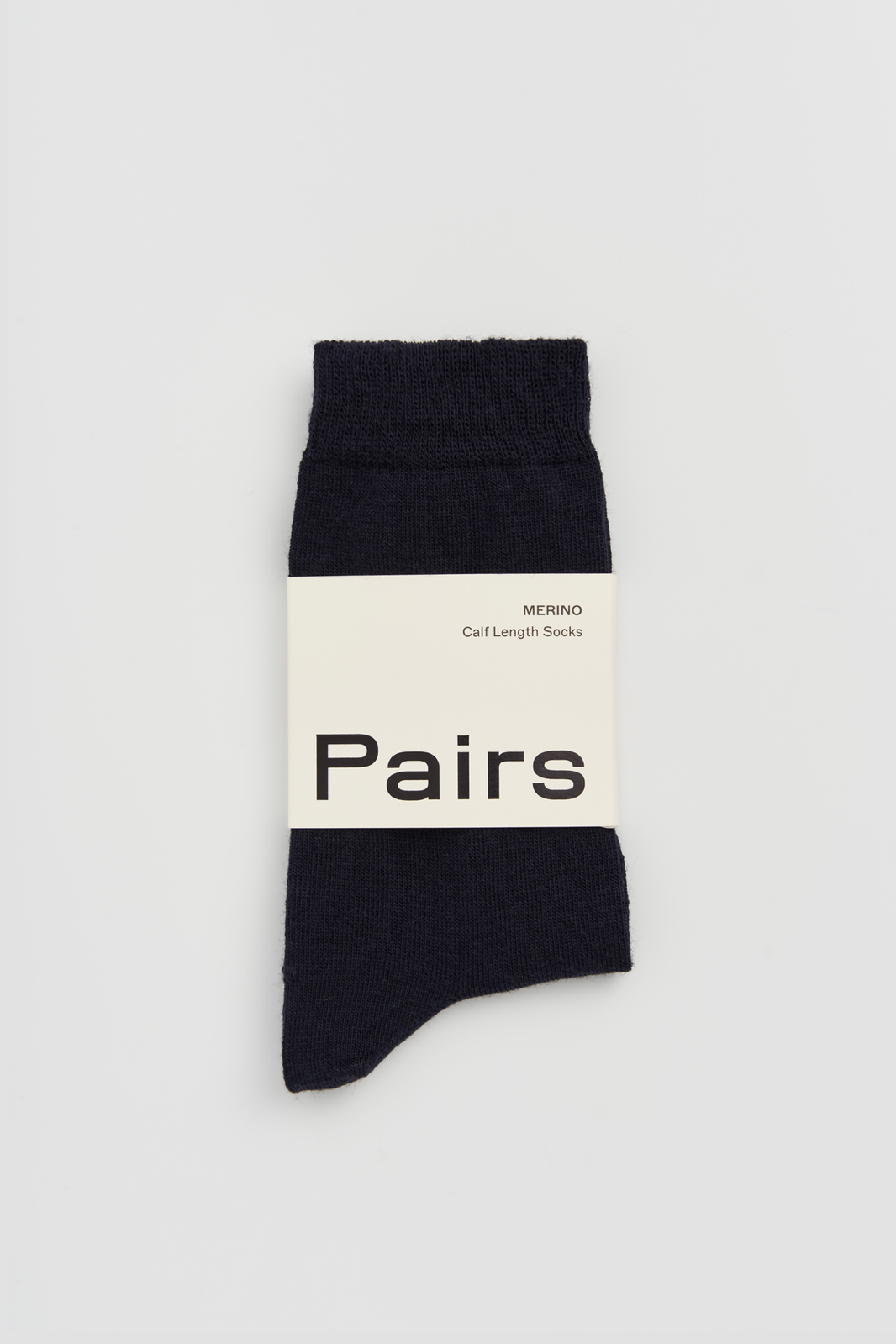 Navy calf-length merino sock with a 'Pairs' packaging band on a light grey background