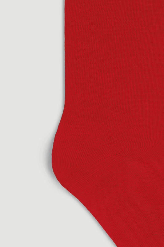 Close-up of the heel of a bright red calf length merino sock on a white background