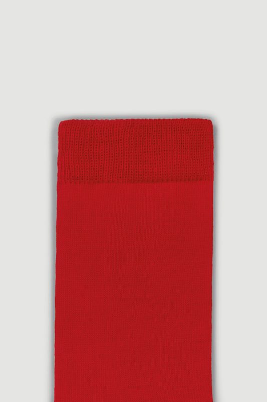 Close-up of the top of a bright red calf length merino sock on a white background