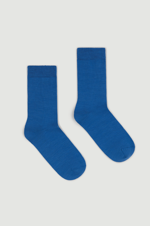 Pair of blue calf length merino socks on a white  background