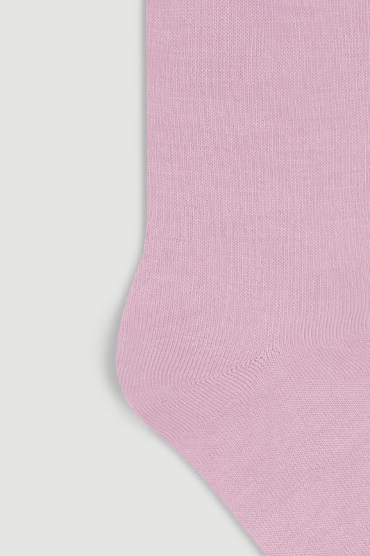 Close-up of the heel of a light pink calf length merino sock on a white background