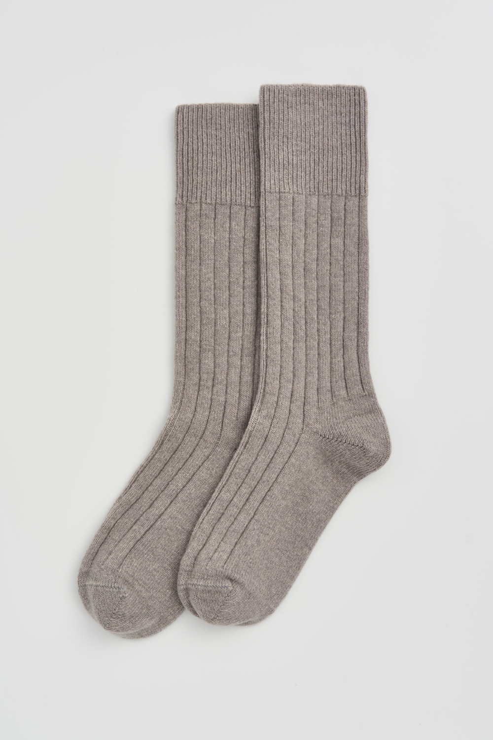 Pair of grey merino ribbed bed socks on a light grey background