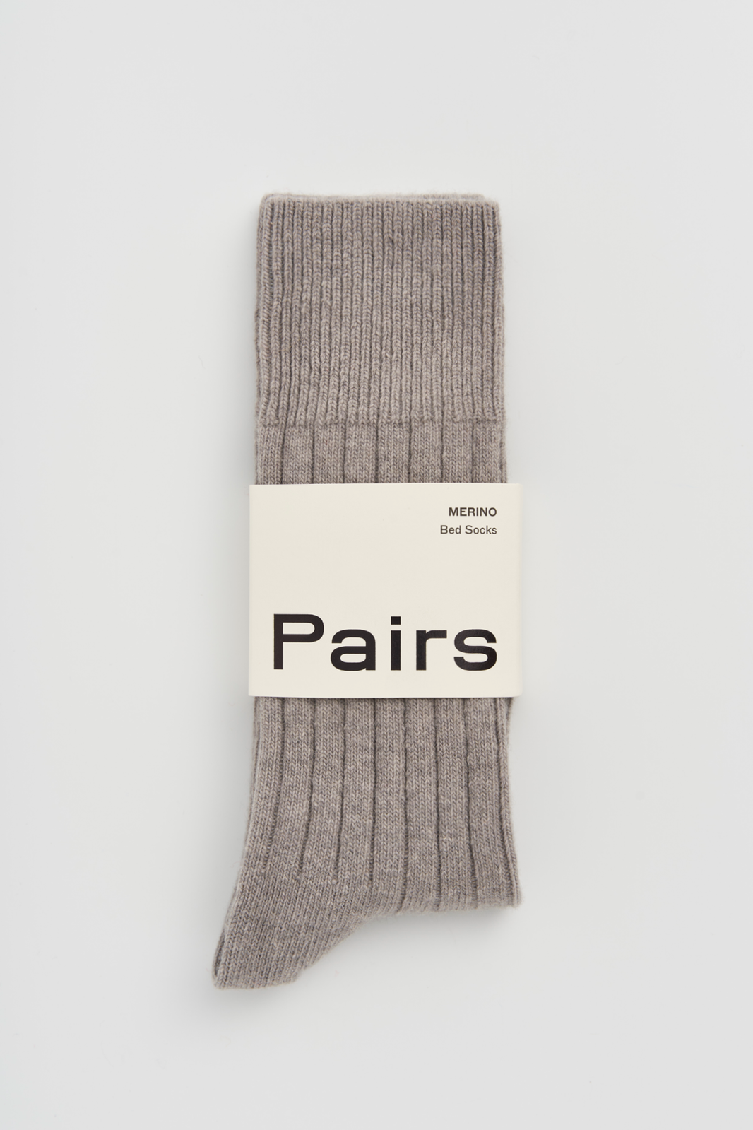 Grey ribbed merino bed sock with a 'Pairs' packaging band on a light grey background