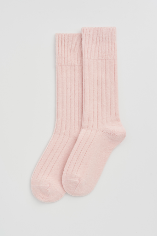 Pair of light pink merino bed socks on a white background