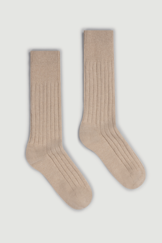 Pair of beige merino ribbed bed socks on a white background