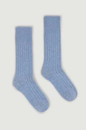 Pair of light blue merino ribbed bed socks on a white background